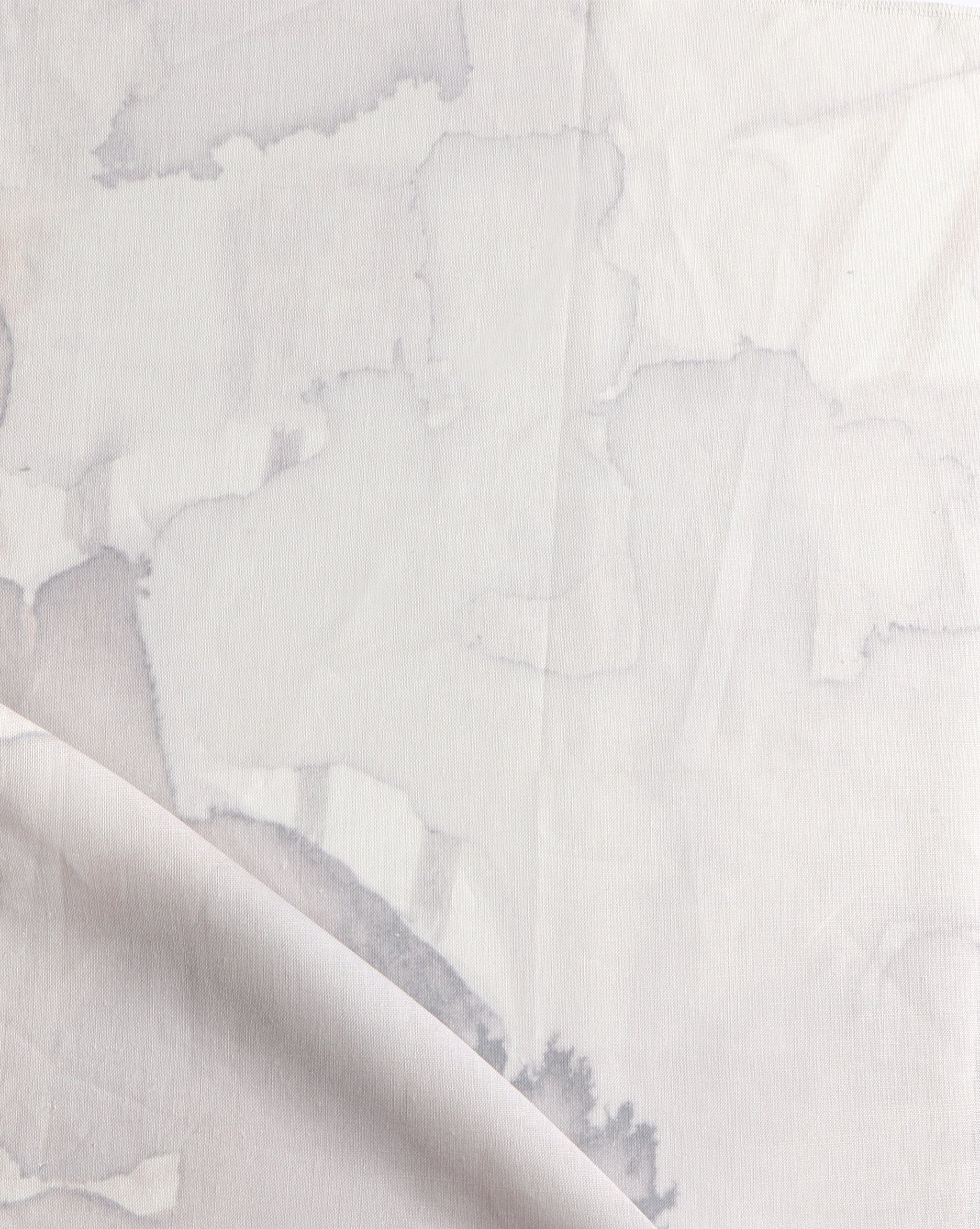 Draped fabric yardage in a watercolor watercolor print in shades of gray and purple on a white field.