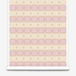 Partially unrolled wallpaper yardage in a gridded paint splatter print in shades of pink, yellow, cream and white.