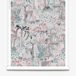 Partially unrolled wallpaper yardage in a painterly tree print in shades of gray, pink and turquoise.