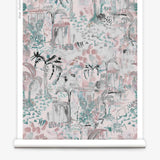 Partially unrolled wallpaper yardage in a painterly tree print in shades of gray, pink and turquoise.