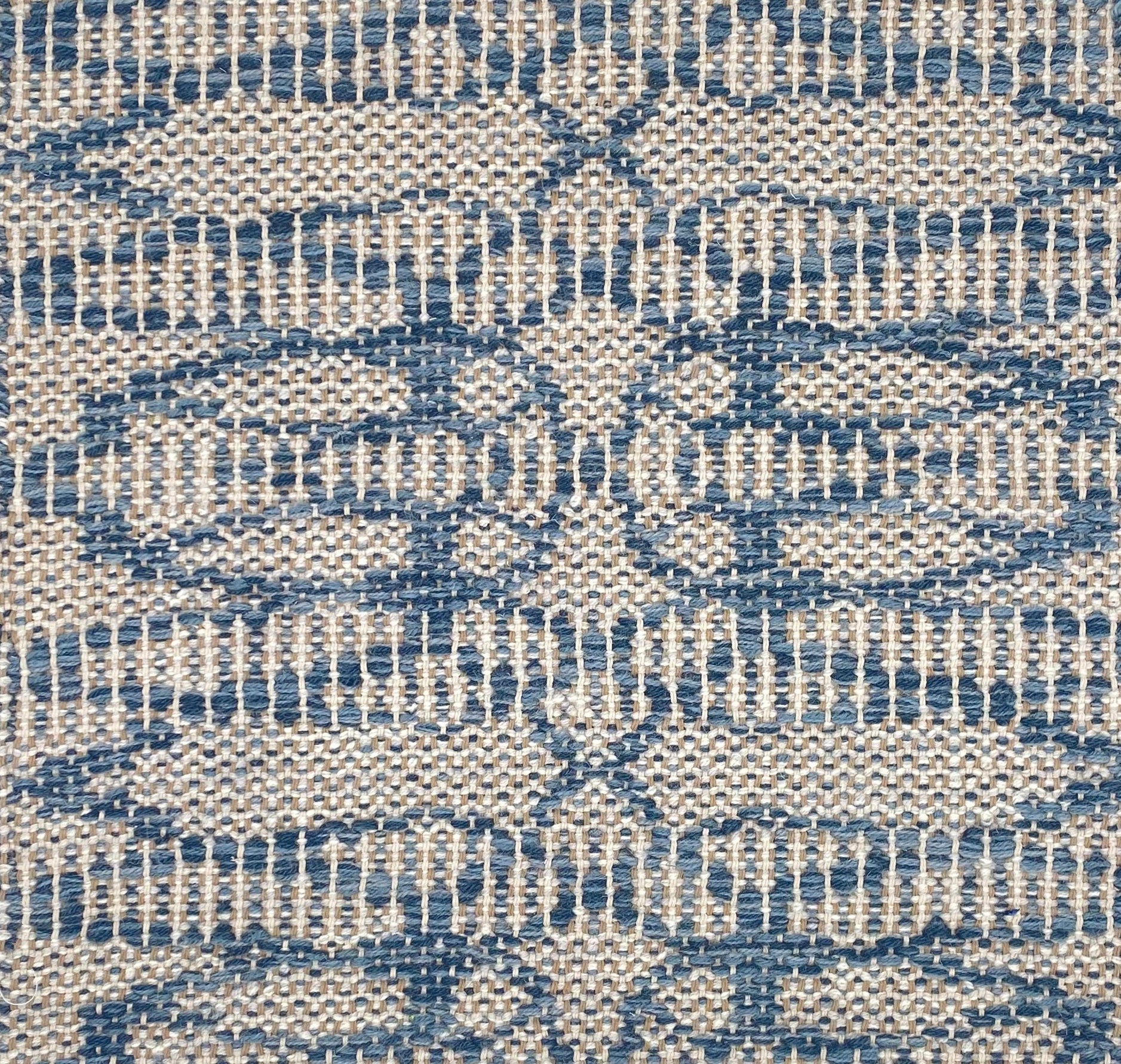 Flatweave rug in an abstract lattice design in blue on a cream field.