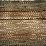 Textural flatweave rug in an ombré stripe in shades of brown, tan, green and cream.