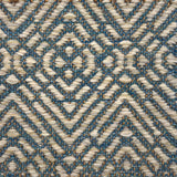 Textural flatweave rug in a raised diamond design in cream on a turquoise field.