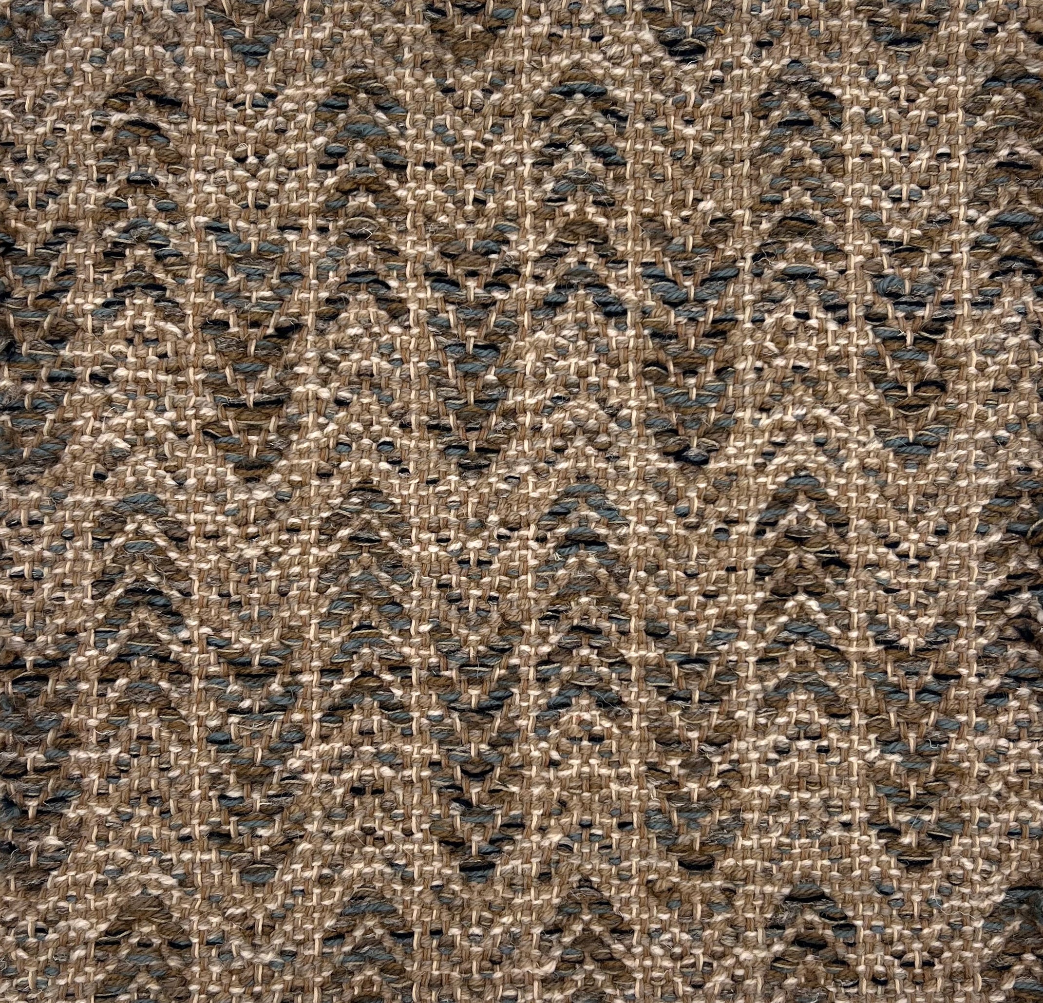 Textural flatweave rug in an arrow stripe design in slate grey and brown on a taupe field.