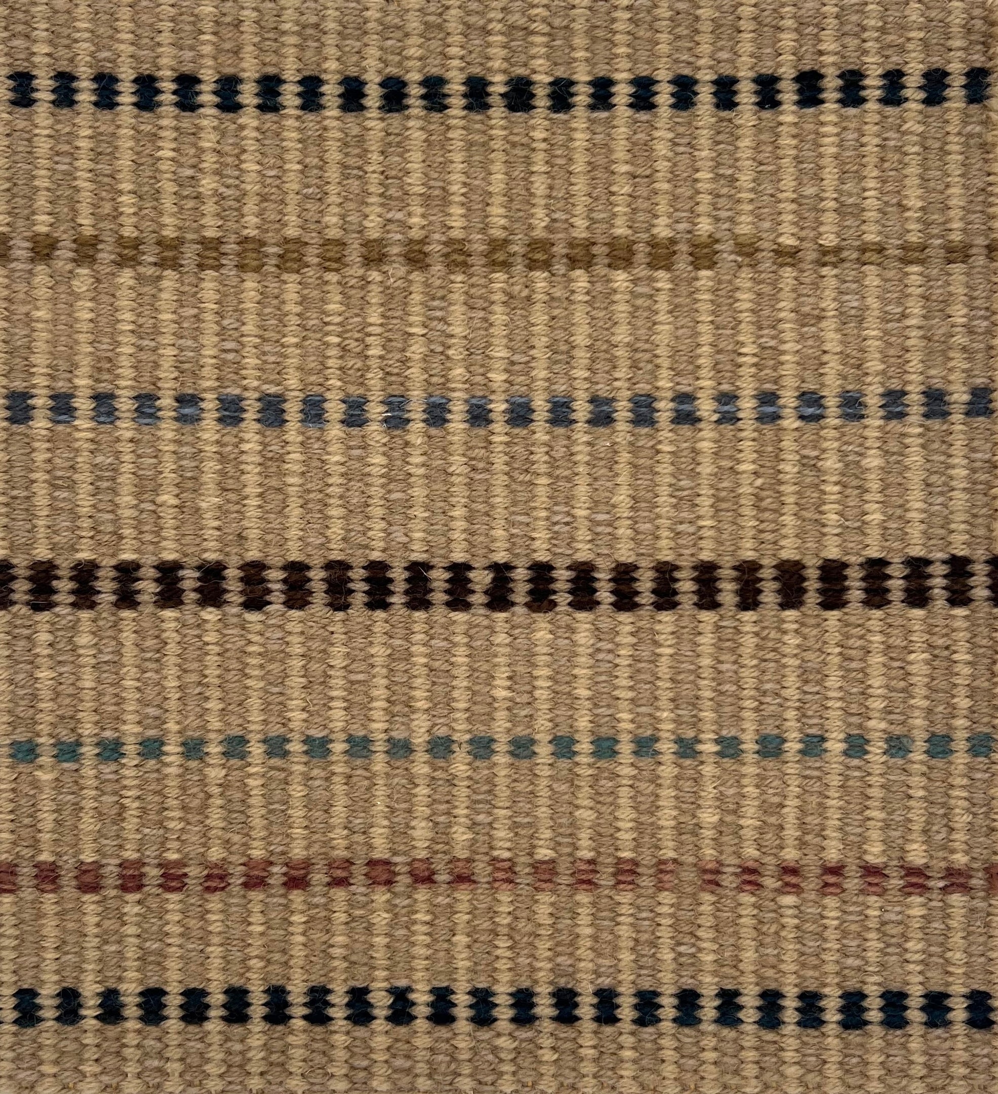 Textural flatweave rug with a dashed stripe design in brown, rust, tan, blue and teal on a tan field.