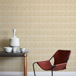 A modernist armchair stands in front of a wall papered in a playful triangular stripe print in tan and light brown.