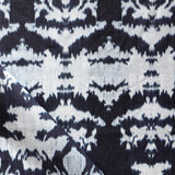 Draped fabric yardage in a watercolor ikat print in shades of blue and navy on a greige field.