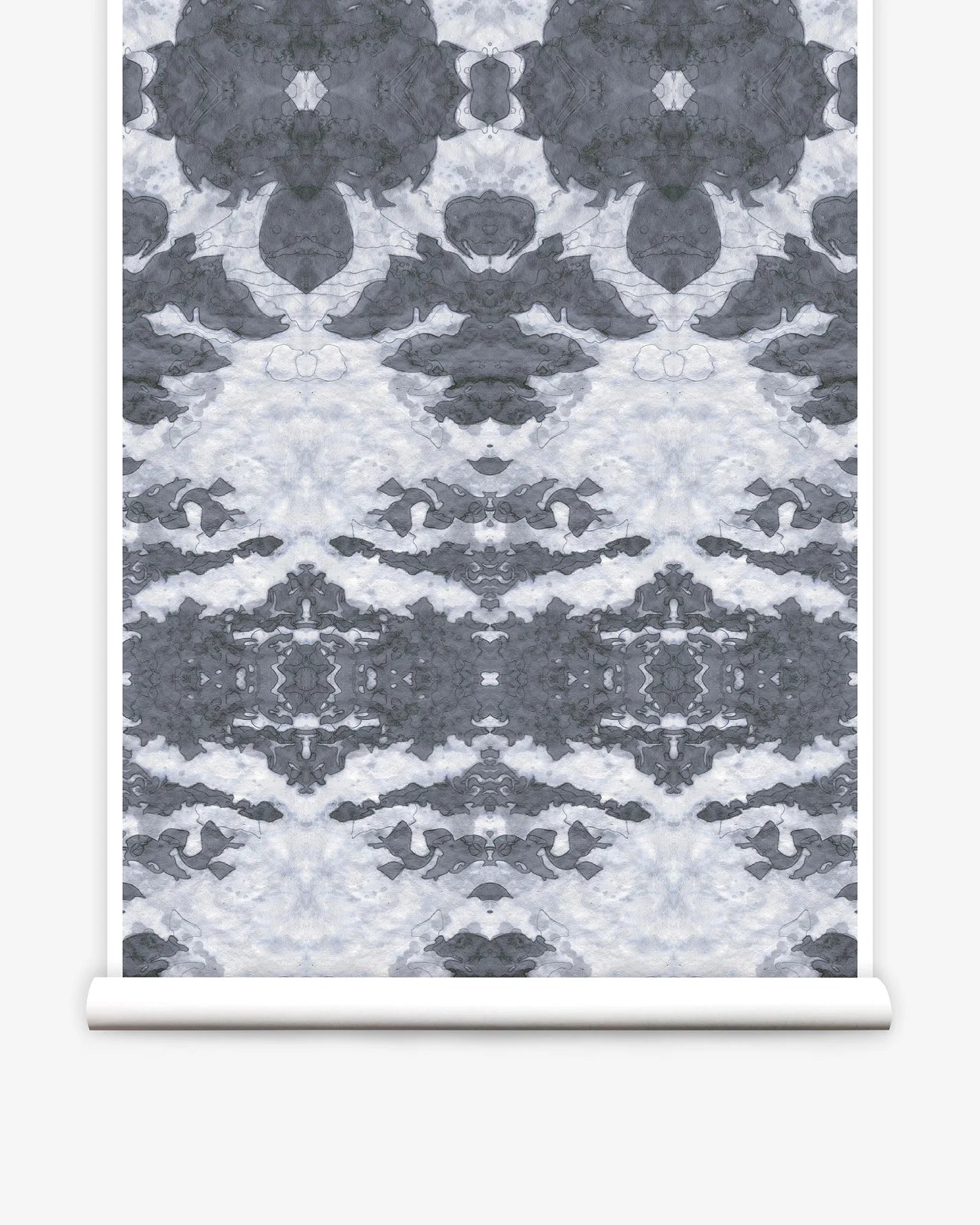 Partially unrolled wallpaper yardage in a painterly ikat print in shades of gray and light blue.