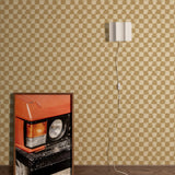 Styled interior vignette with a framed photo of a close up on an orange retro car, dark wood floors, white wall sconce with cord trailing out of the frame with a tan and beige checkerboard wallpaper backdrop.