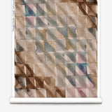 Partially unrolled wallpaper yardage in a painterly check pattern in shades of brown, blue and pink.