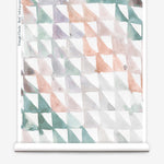 Partially unrolled wallpaper yardage in a painterly check pattern in shades of coral, purple, green and white.