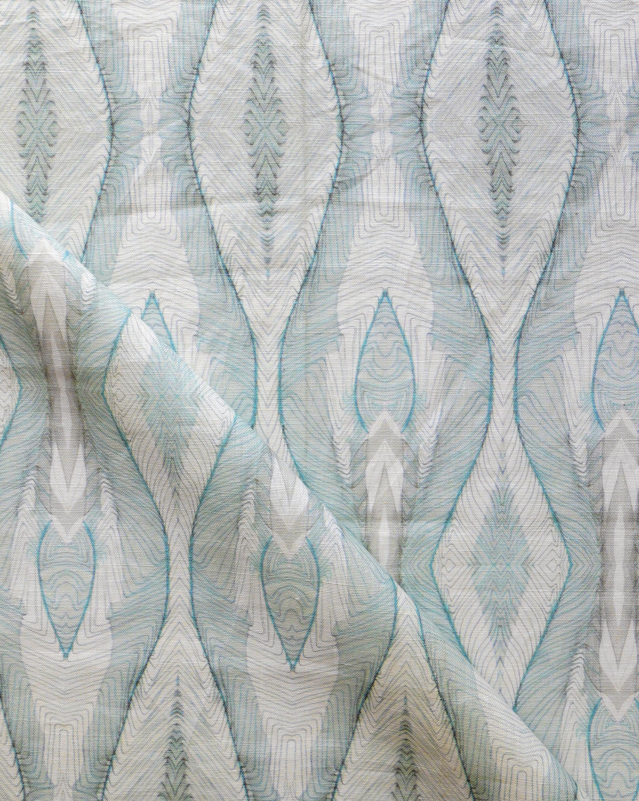 Draped fabric yardage in a watercolor diamond print in shades of gray and blue on a cream field.