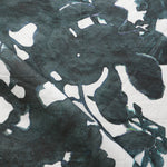 Draped fabric yardage in a watercolor tree print in navy and black on a cream field.