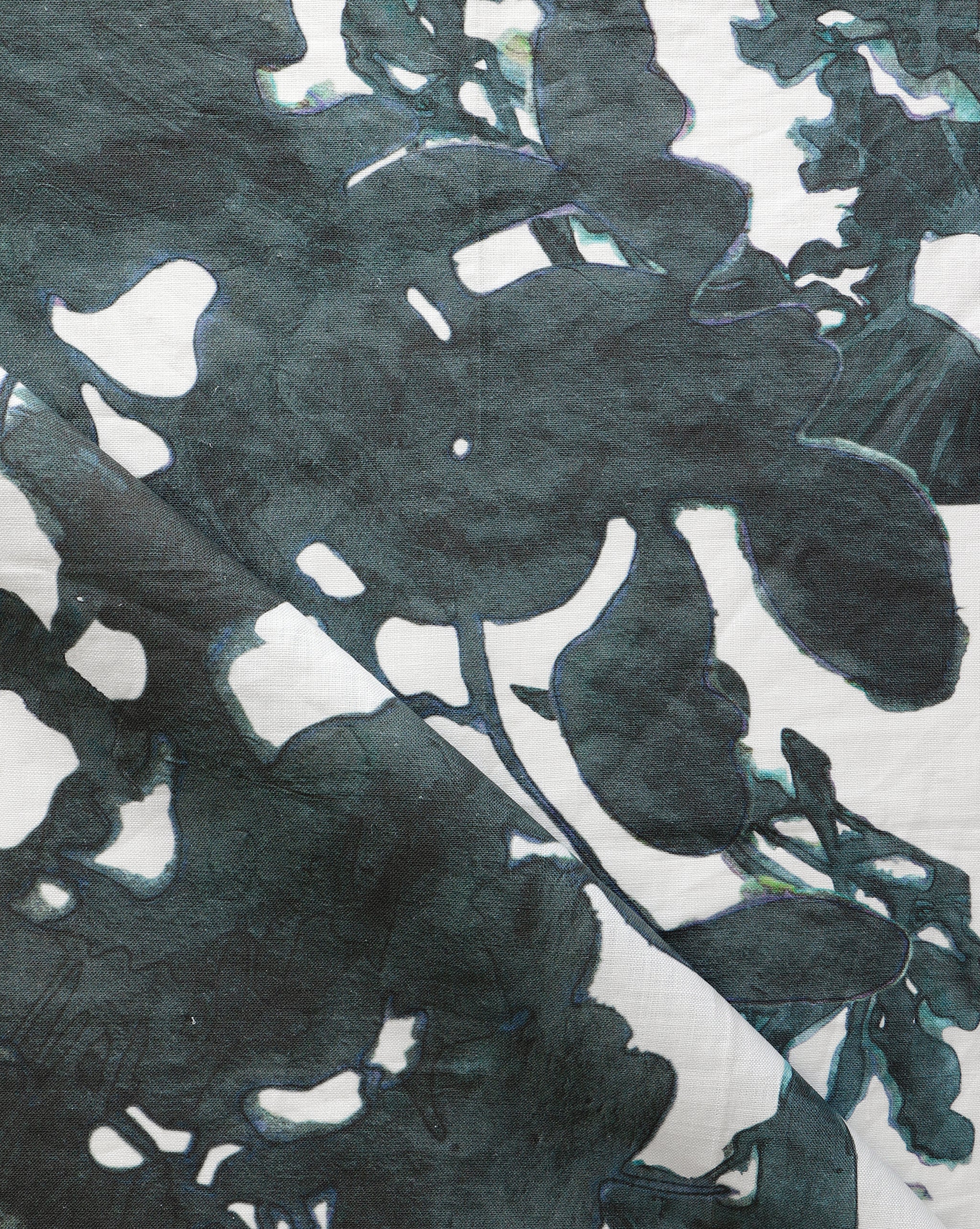 Draped fabric yardage in a watercolor tree print in navy and black on a cream field.