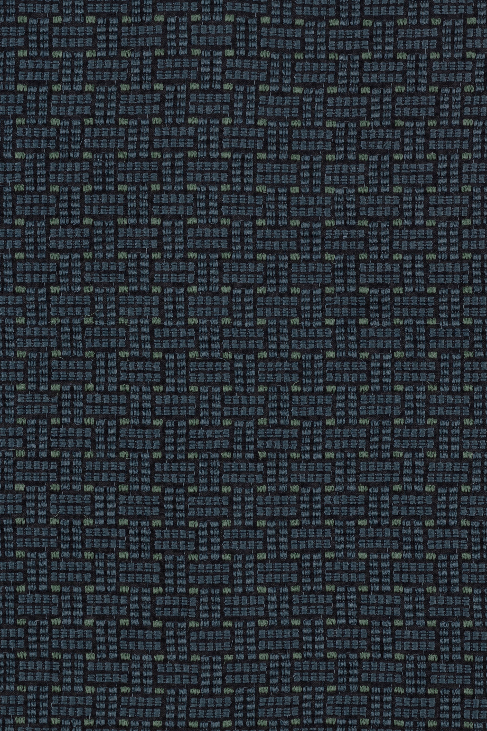 Embroidered fabric in a dashed basketweave design in navy blue with green accents.