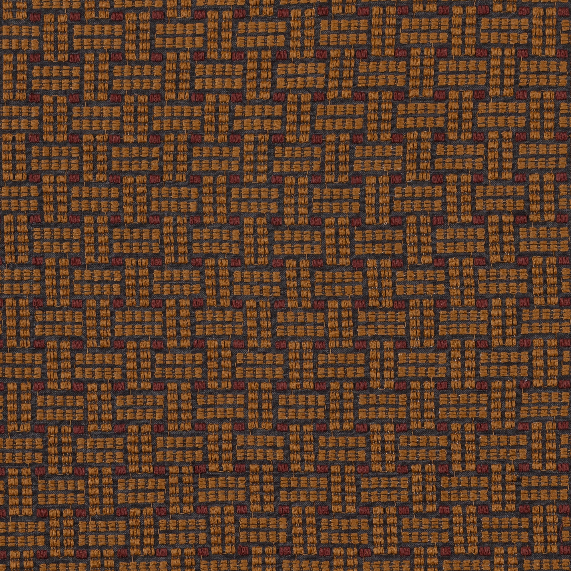 Embroidered fabric in a dashed basketweave design in caramel brown with red accents.