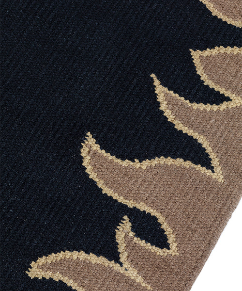 Detail of a flatweave rug with a flame border design in taupe on a black