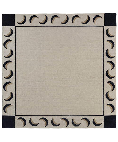 Flatweave rug with a crescent moon border in cream, taupe and black.