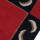 Detail of a flatweave runner with a crescent moon border in cream, taupe and black of a red field.