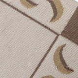 Detail of a flatweave runner with a crescent moon border in cream, taupe and brown