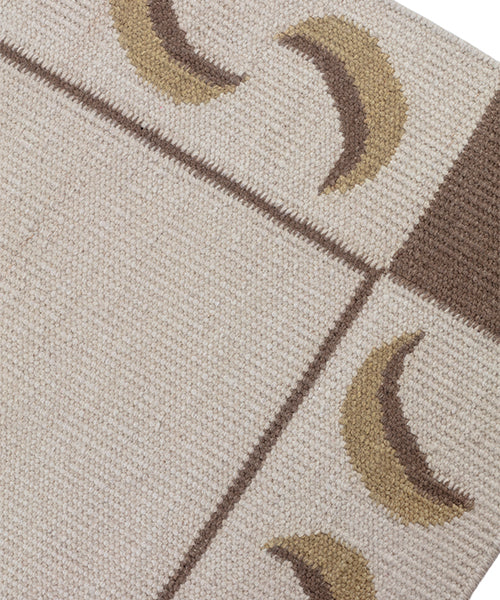 Detail of a flatweave runner with a crescent moon border in cream, taupe and brown