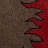 Detail of a handknotted rug with a flame border design in red on a brown field. 