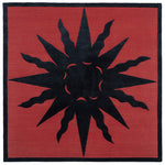 Handknotted rug with a raised sun motif in black on a red field with thin black border.
