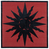 Handknotted rug with a raised sun motif in black on a red field with thin black border.