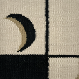 Detail of a flatweave rug with a crescent moon border in cream, taupe and black.