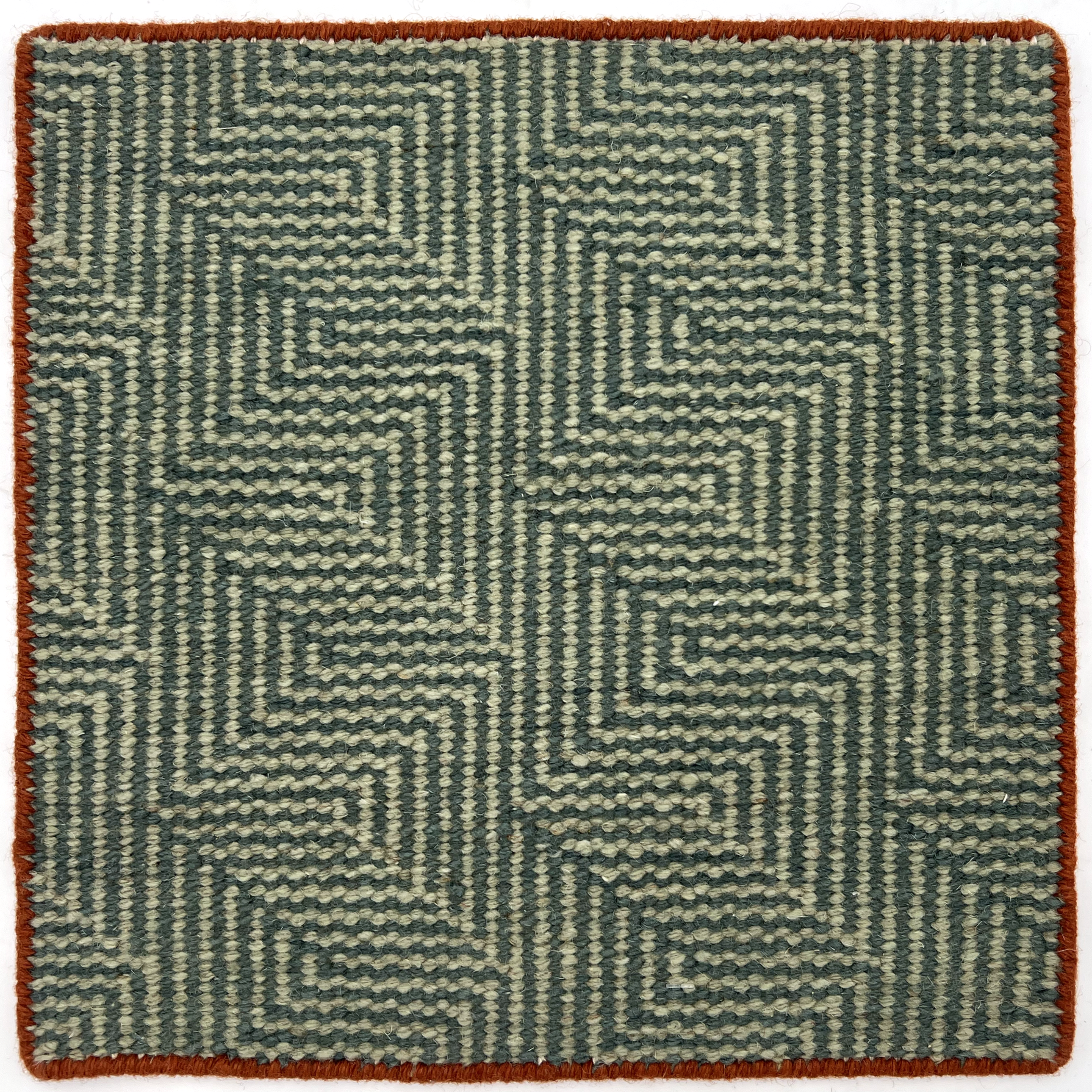Flatwoven rug in a dense stripe zig zag in sage and emerald with a thin rust border.
