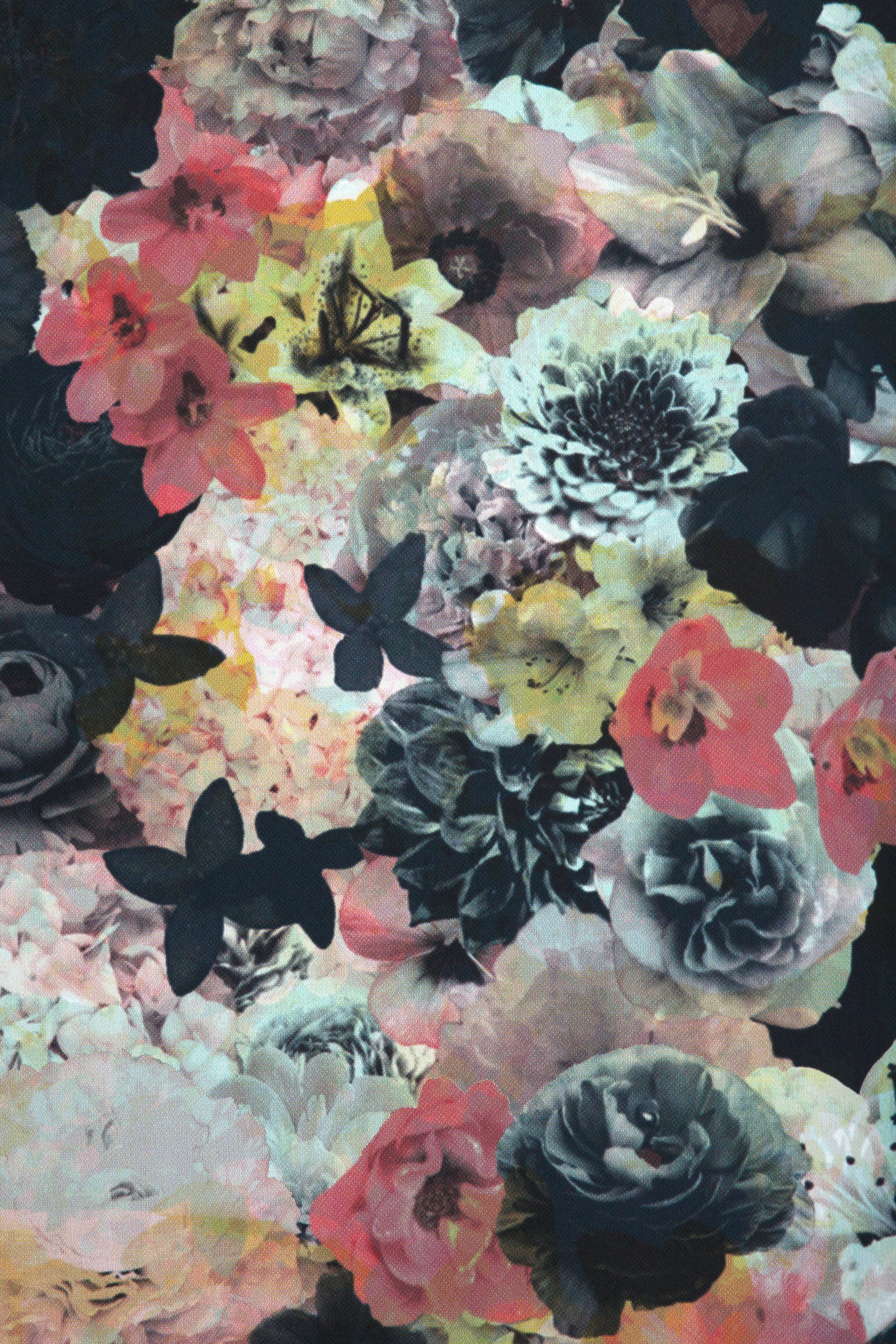 Detail of wallpaper in a dense photorealistic floral print in shades of pink and green on a navy field.