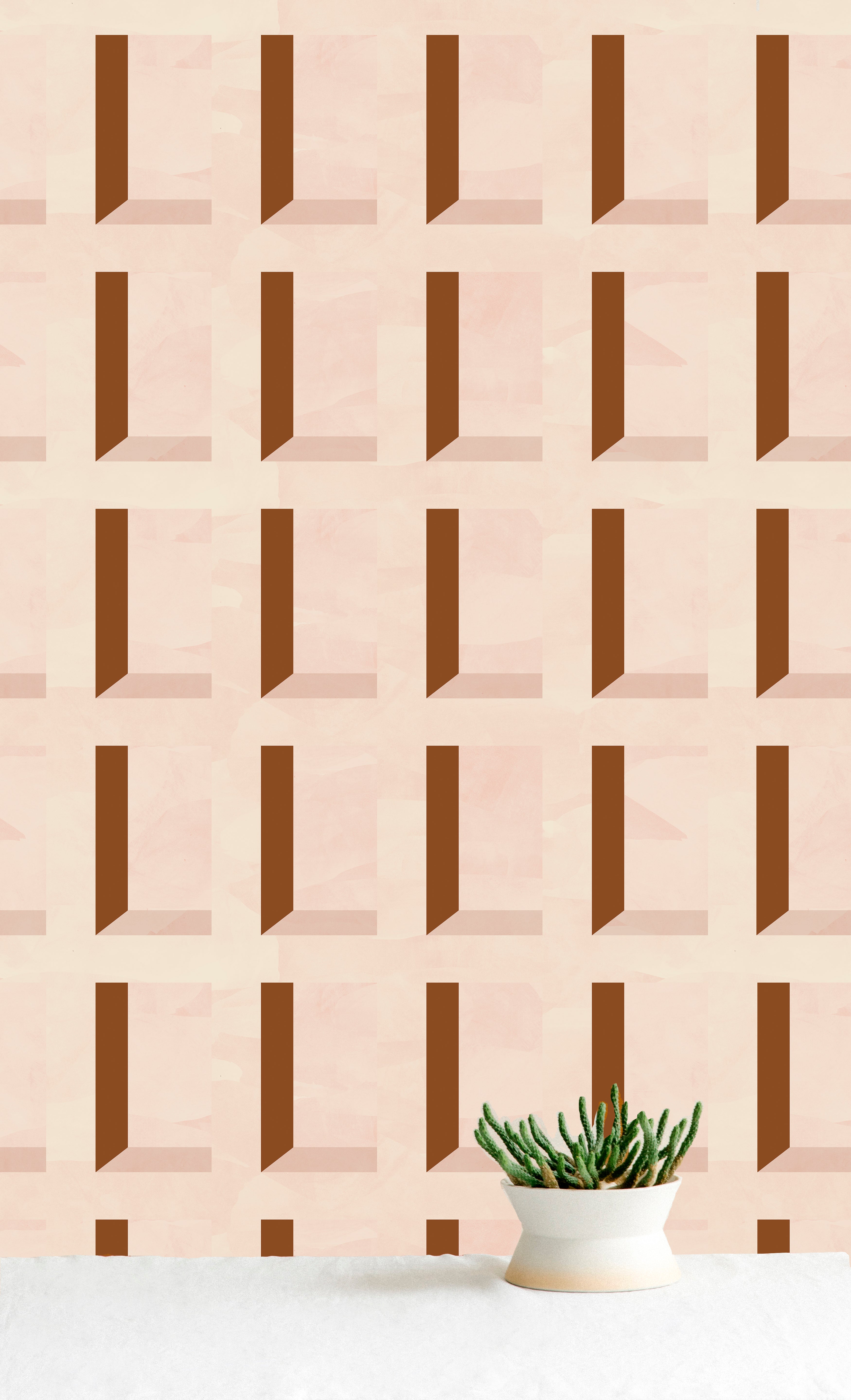 A potted cactus stands in front of a wall papered in a dimensional grid print in shades of cream and rust.