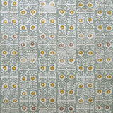 Wallpaper in a repeating damask print in mustard and white on a blue-gray field.