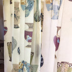 Curtain in a printed fabric panel with ornate decorative urns.