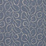 Woven fabric swatch with a large-scale repeating leaf print in tan on a French blue background.