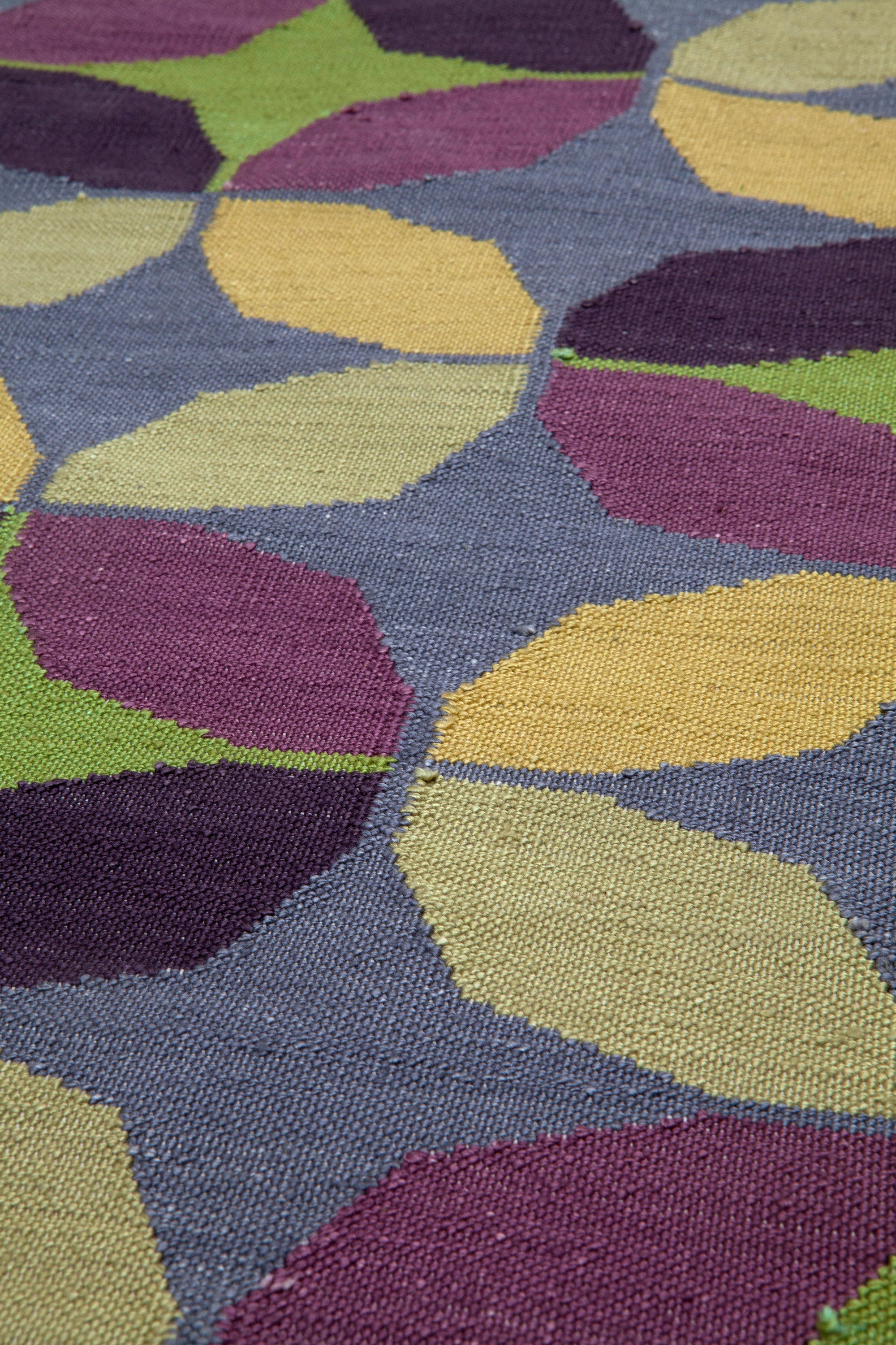 Detail of Alhambra Rug in multi color yellow, green, magenta, purple and blue featuring a pattern of linked circles that create a star like lattice
