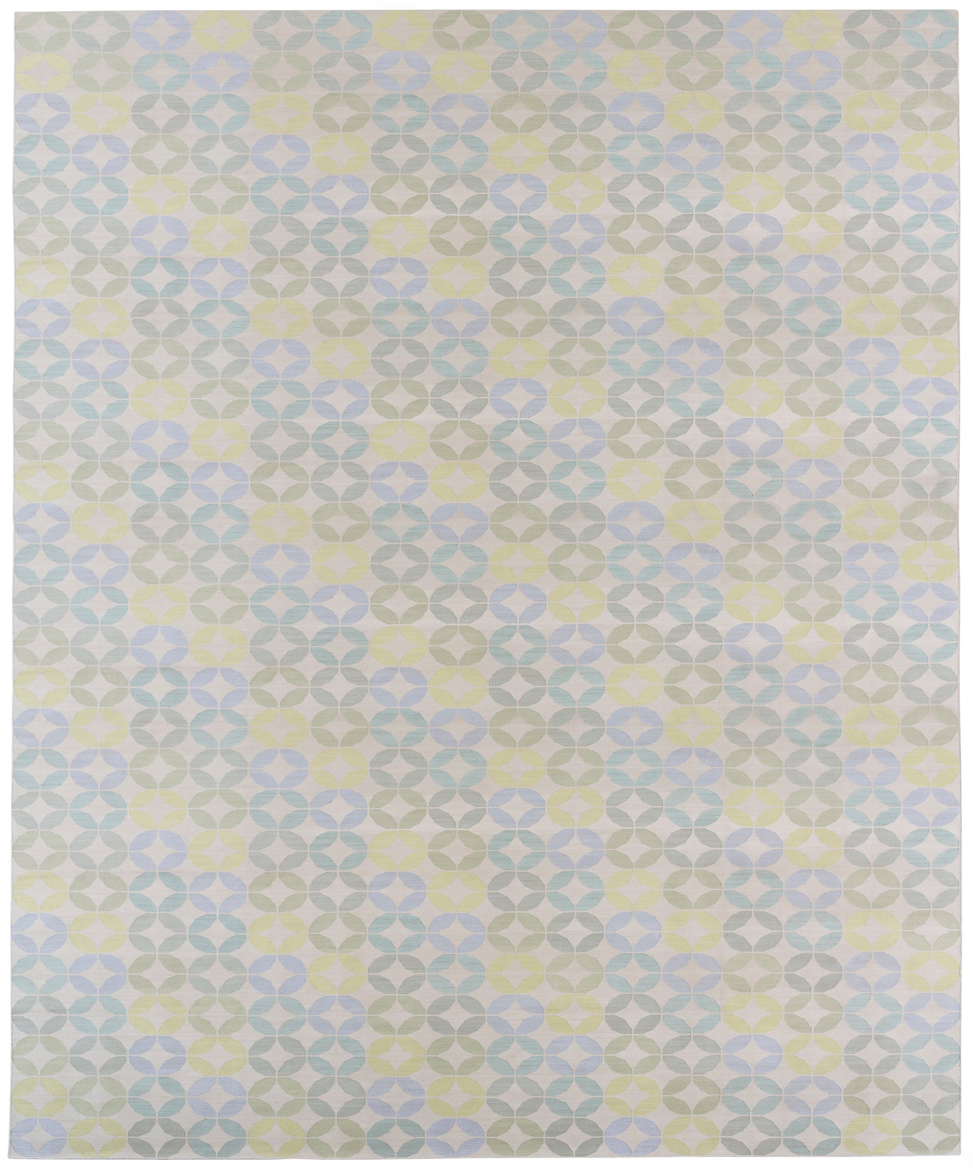 Detail of Alhambra Rug in Mint featuring a pattern of linked circles that create a star like lattice in a range of pastel turquoise, mint, yellow and lime green on a soft beige field. 