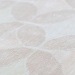 Detail of Alhambra Rug in Stonewash featuring pattern of linked circles that create a star like lattice in a range of pale pink tones a soft white field. 