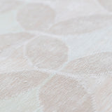 Detail of Alhambra Rug in Stonewash featuring pattern of linked circles that create a star like lattice in a range of pale pink tones a soft white field. 