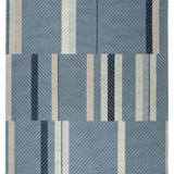 Full size Amelia Rug in Lapiz featuring a minimalist broken stripe pattern, overlayed with thin light blue diagonal lines. The broken stripes are a mix of navy blue, pale blue. white and turquoise with black accents, all on denim blue field.