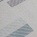 Detail of the Amelia Rug in Pearl featuring a minimalist broken stripe pattern, overlayed with thin white diagonal lines. The broken stripes are a mix of pale blues, grey, and turquoise with slate grey accents, all on a pale grey field. 