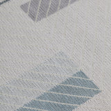 Detail of the Amelia Rug in Pearl featuring a minimalist broken stripe pattern, overlayed with thin white diagonal lines. The broken stripes are a mix of pale blues, grey, and turquoise with slate grey accents, all on a pale grey field. 