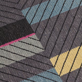 Detail of the Amelia Rug in Spinel featuring a minimalist broken stripe pattern, overlayed with thin black diagonal lines. The broken stripes are a mix of white, grey, kelly green, denim blue, black with hot pink accents, all on a charcoal grey field. 