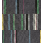Full Size Amelia Rug in Spinel featuring a minimalist broken stripe pattern, overlayed with thin black diagonal lines. The broken stripes are a mix of white, grey, kelly green, denim blue, black with hot pink accents, all on a charcoal grey field. 