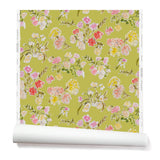 Partially unrolled wallpaper with a pattern of large-scale line-drawn flowers in gray ink with red, pink and yellow watercolors, on a light green background.