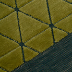 Detail of the Bucky Rug in citrine-jade, features a wide dark sage green border with a chartreuse colored lattice field with a metallic sheen. 