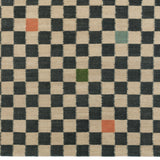 Detail of the Checkerboard Rug in King, a black and tan checkered pattern with random accents of green, sky blue and coral orange. 
