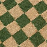 Detail of the Checkerboard Rug in Pawn, a green and tan checkered pattern. 