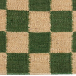 Detail of the Checkerboard Rug in Pawn, a green and tan checkered pattern. 