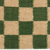 Detail of the Checkerboard Rug in Pawn, a green and tan checkered pattern. 